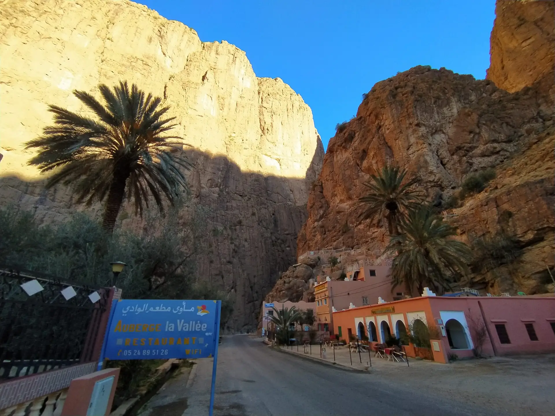 Entrée des gorges de Toudgha au Maroc dans la région de Tinghir, avec des palmiers au premier plan.
