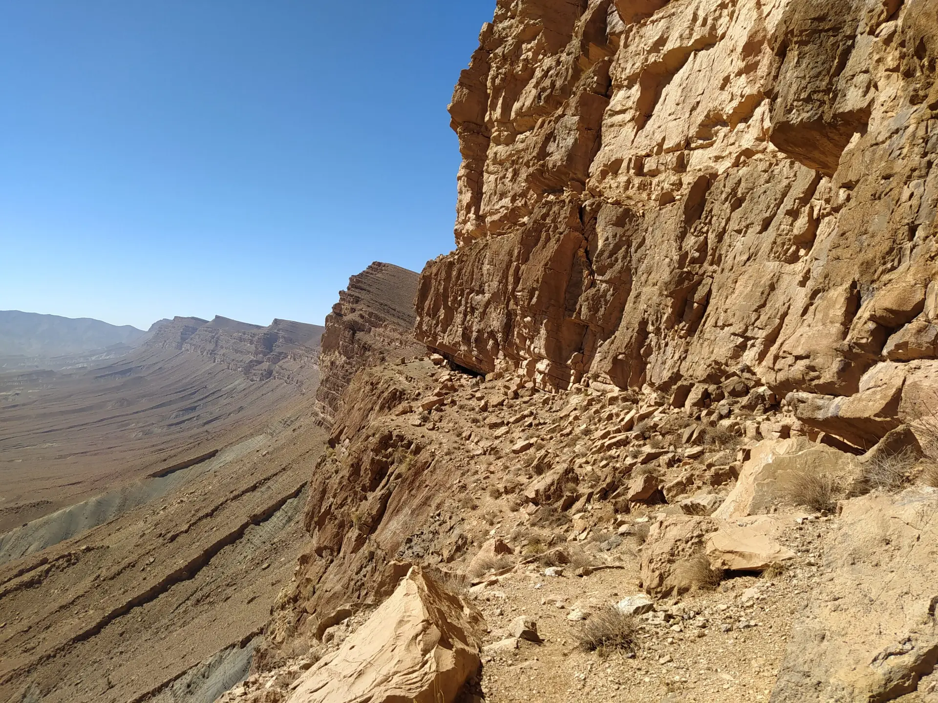 Passage sur une vire au milieu d'une falaise dans le désert marocain.