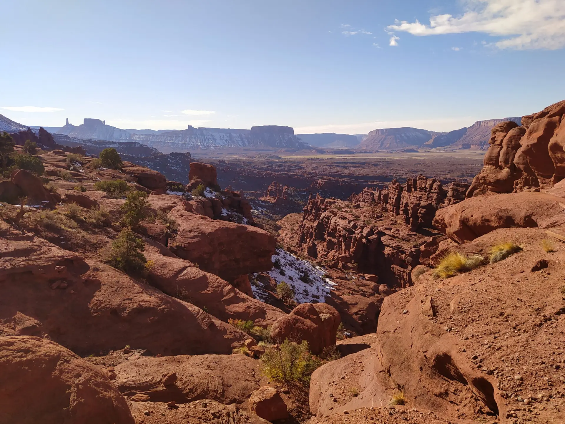Sand stone landscape in Moab with surprising geological shapes, in the far left background is Castleton tower.