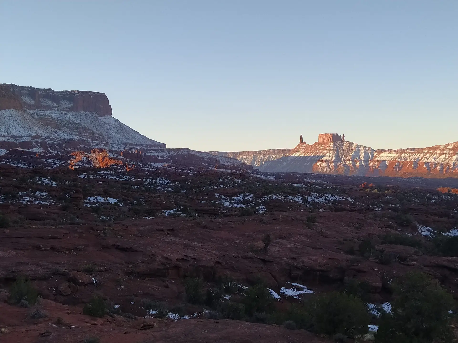 Snow in the Utah desert with Castleton Tower in the far background during a base jumping trip led by BASE Spirit.
